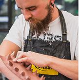 Student sculpting a spiky arm guard