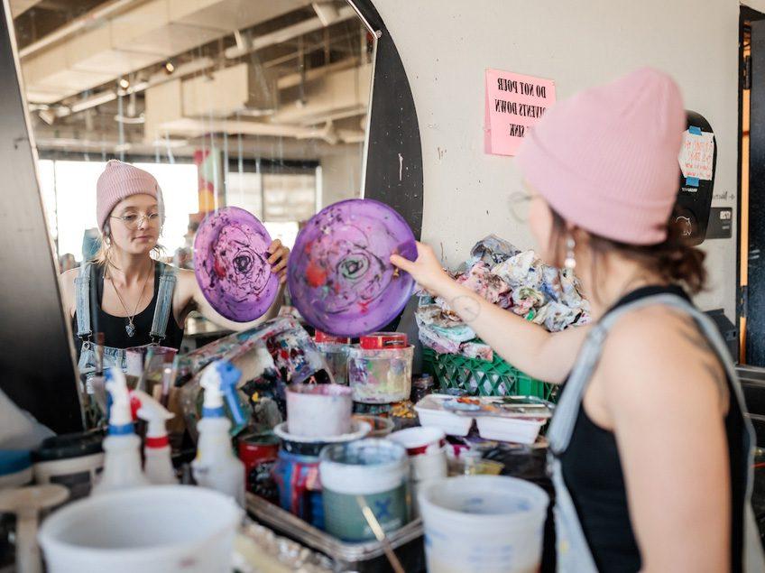 MSU Denver student, Katelin Knudsen, reaches for a paint palette in Painting and New Contexts class on May 3, 2023. Photo by Alyson McClaran